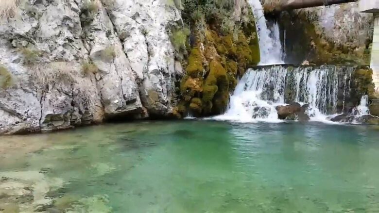 Clear turquoise pool and cascading waterfalls at Duman Spring, surrounded by limestone cliffs near Livno, Bosnia and Herzegovina.