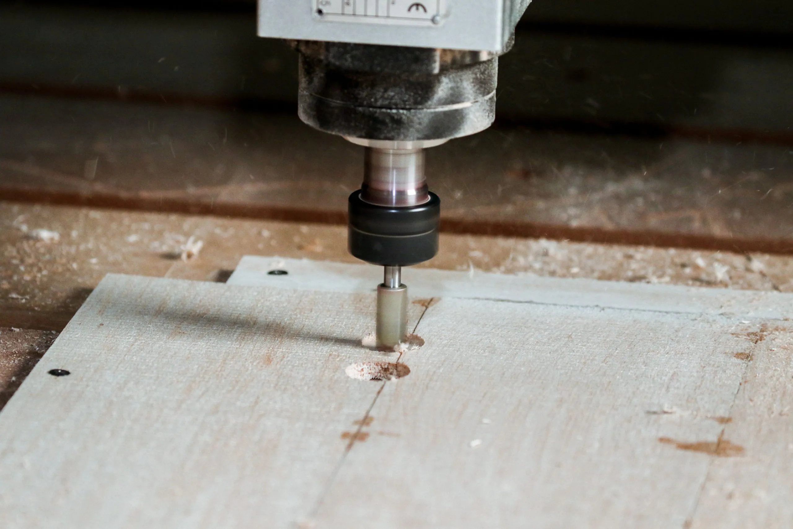 CNC router cutting a wooden workpiece in a workshop, illustrating the tool's carving and milling capability.